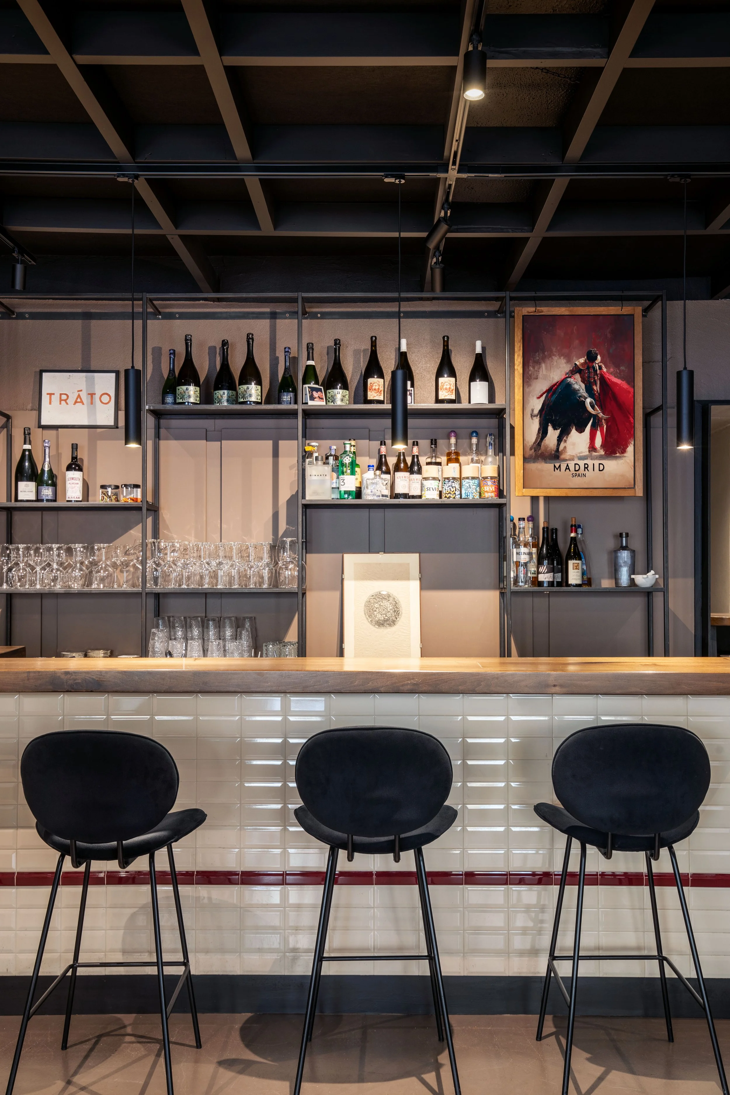 bancone per cena "a la barra", retrobancone in ferro, top bancone in legno trattato e luci puntuali a sospensione