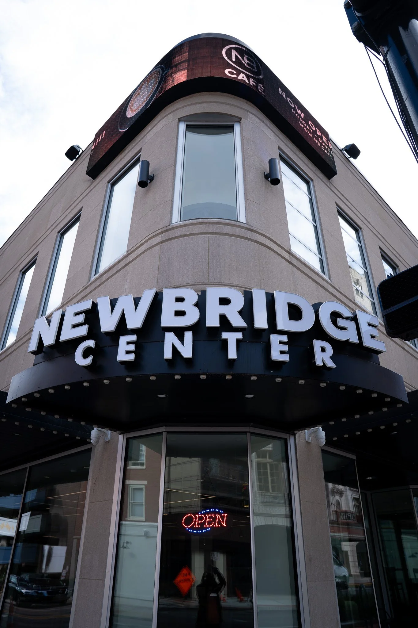 External view of a building with signage reading 'Newbridge Center' and a neon 'Open' sign in the window.
