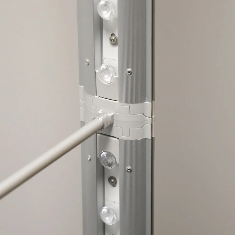 Close-up of a door hinge with a metal rod attached, surrounded by small LED lights and screws.