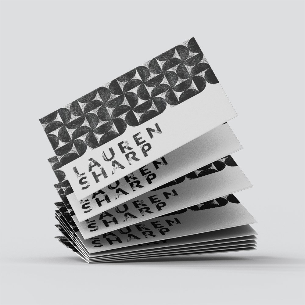 Stack of brochures or flyers with a black and white geometric pattern and the text 'LAUREN SHARP' on the cover.