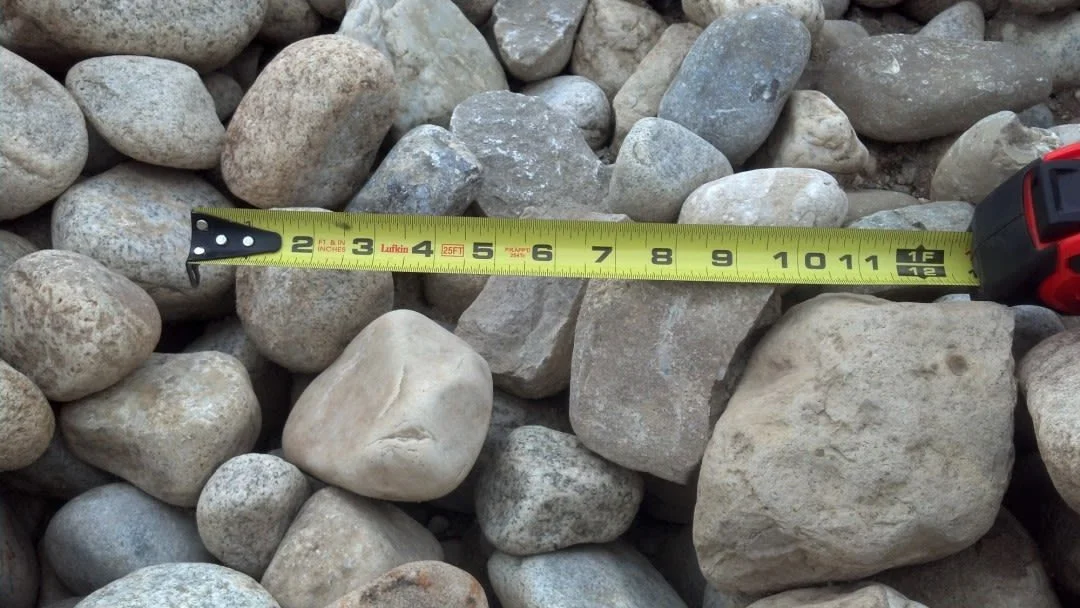 Photo of oversized screen rock with a measuring tape to show the rocks' dimensions.