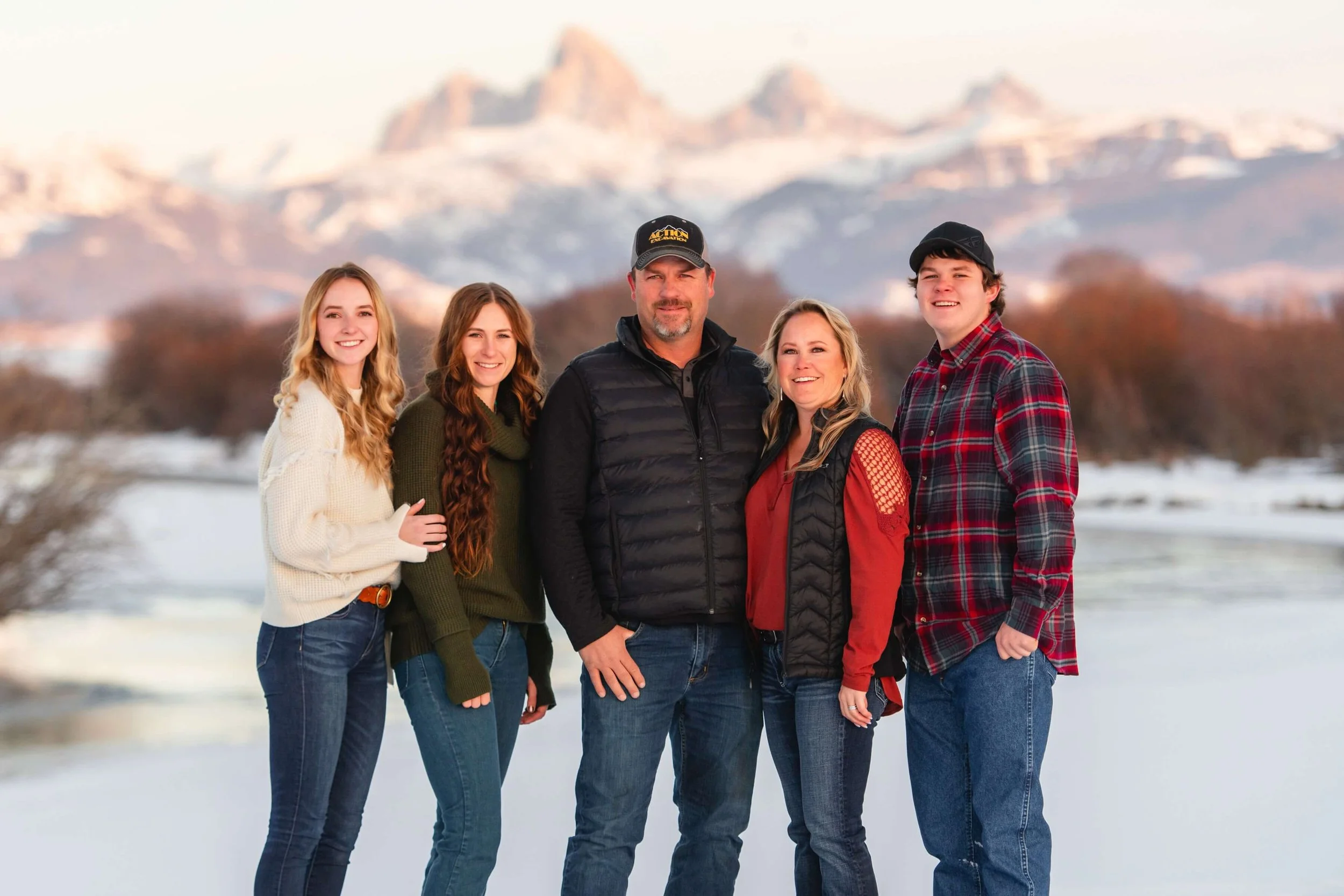 Photo of Brandon and Jamie Lerwill's family with Teton peaks behind them. They own Action Excavation.