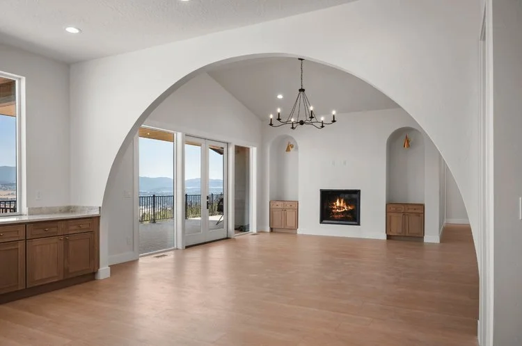 Beautiful arched ceiling in this white living room with wood floors and fireplace - Custom Home Builders WA - Diamond Homes