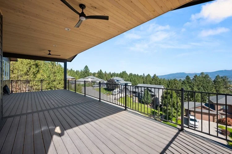 Spacious back patio with a solid deck and a gorgeous view of trees and other houses - Home Builders WA - Diamond Homes