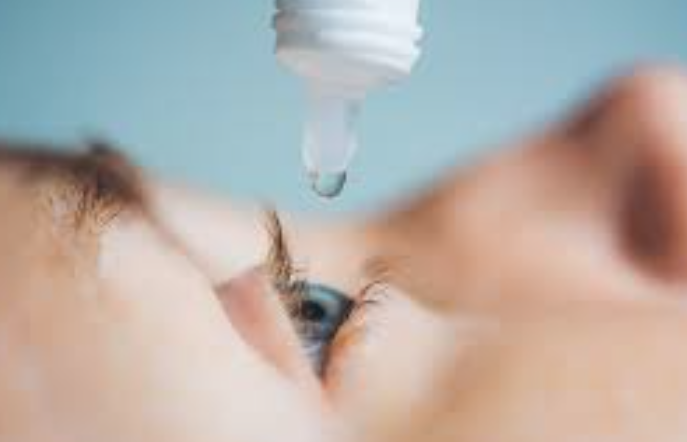 Close-up profile view of a child receiving a low-dose atropine eye drop, demonstrating the simple, once-daily pharmacological treatment method used to slow down progressive childhood myopia and control axial lengthening.