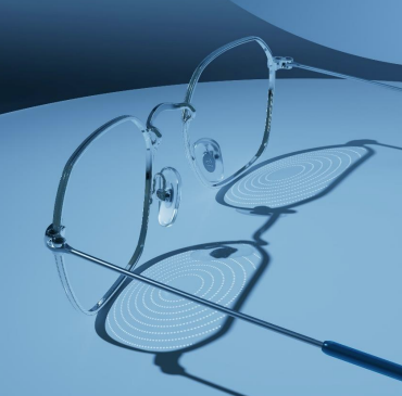 Close-up view of an Essilor Stellest myopia control lens, showing the subtle pattern of concentric rings of microscopic aspherical lenslets (H.A.L.T. technology) on the surface.