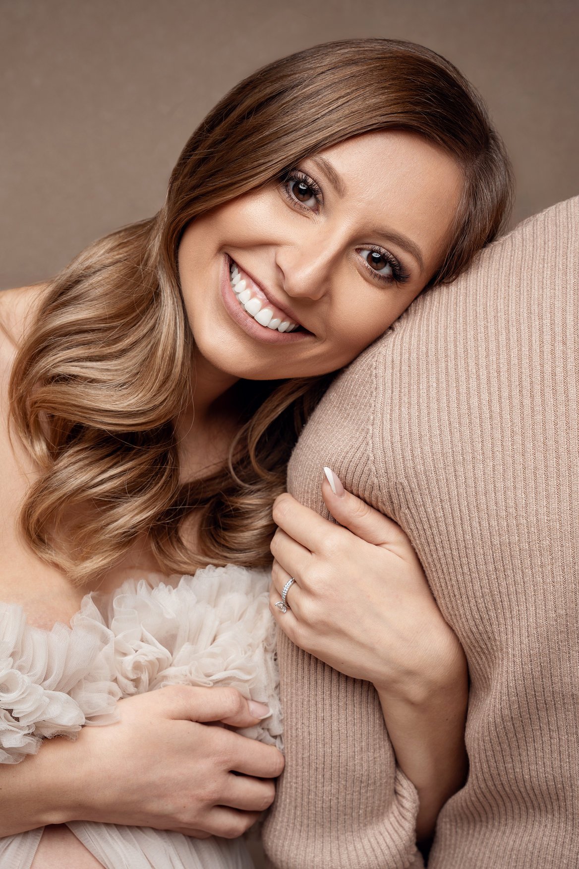 Maternity portrait session with smiling woman hugging pillow in Chicago - Filaneyka photo studio