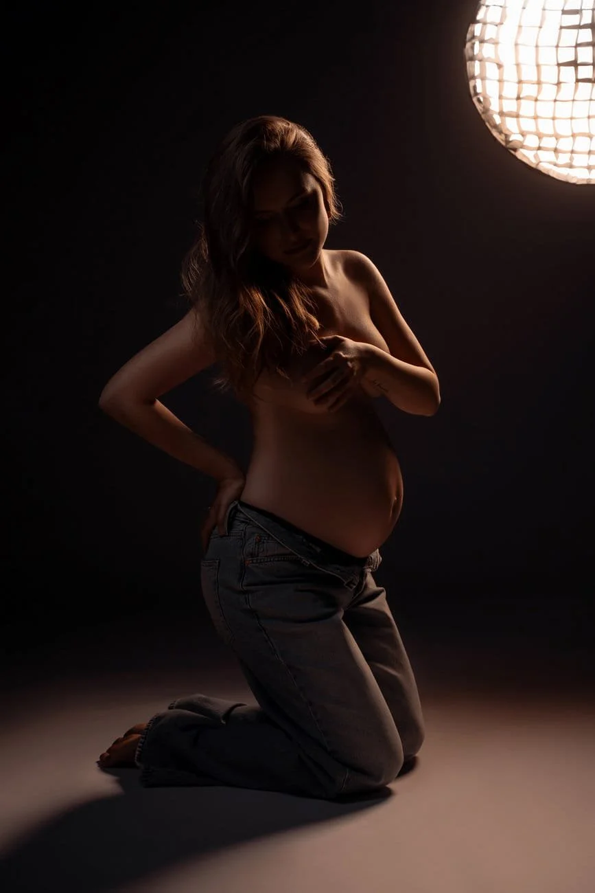 Pregnancy photography with dramatic backlit pregnant silhouette in jeans in Chicago - Filaneyka photo studio