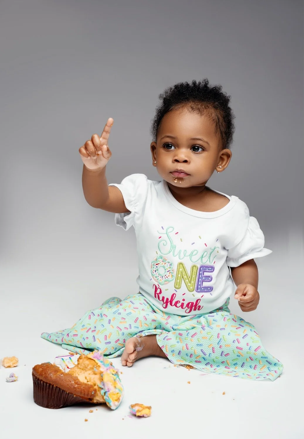  1-year-old baby girl's first birthday cake smash portrait in a "Sweet One" personalized shirt, Filaneyka Photo Studio Chicago 