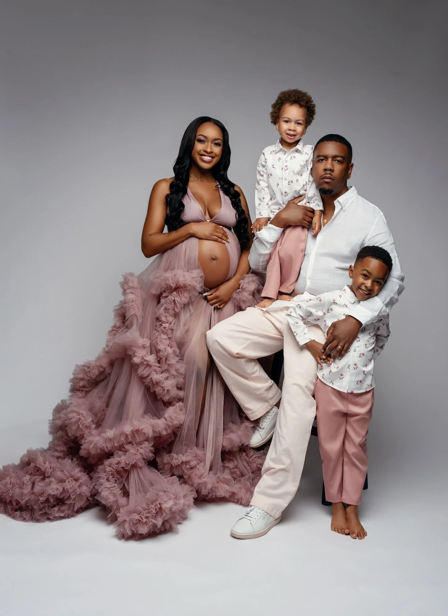  Elegant family maternity studio portrait with pregnant mother in flowing pink dress, father and two children 
