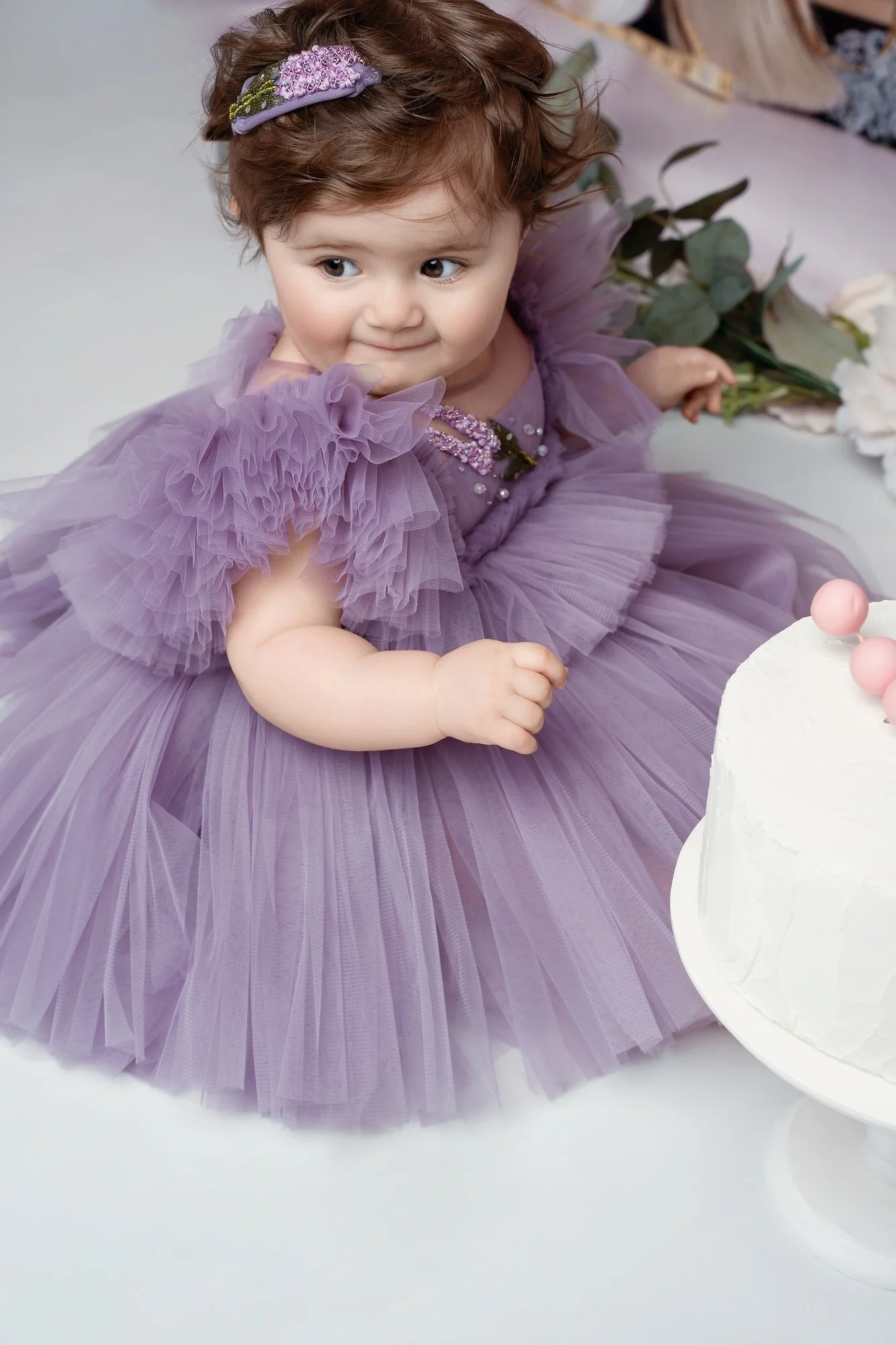  One-year-old girl meeting a real cake during a cake smash photo session in Chicago 