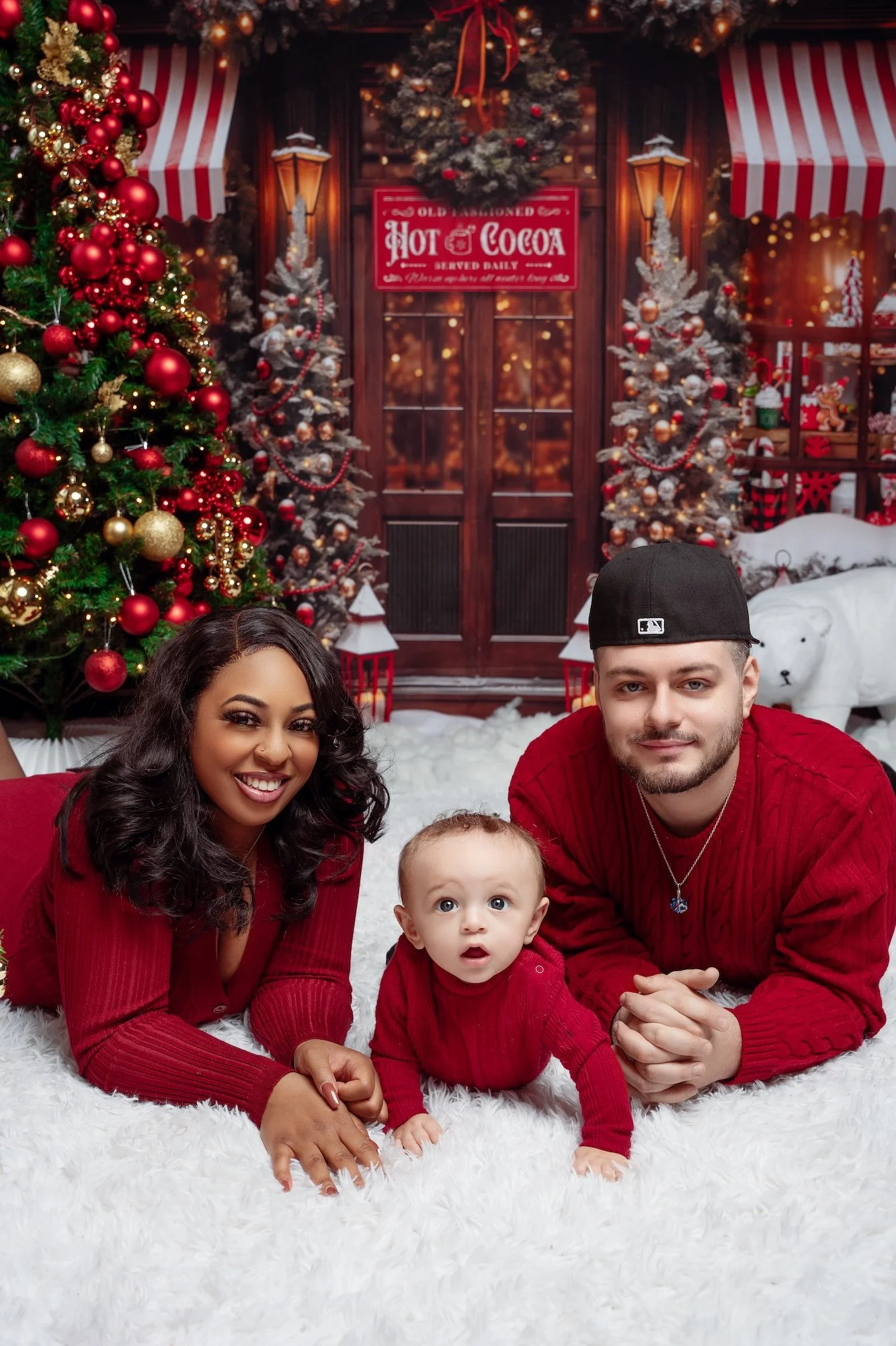  Family laughing together during a Christmas photo session in Chicago studio, matching red holiday outfits. 
