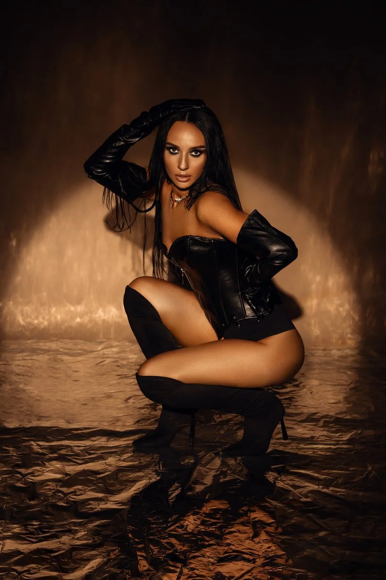 Professional portrait session with model crouching in black leather in Chicago - Filaneyka photo studio