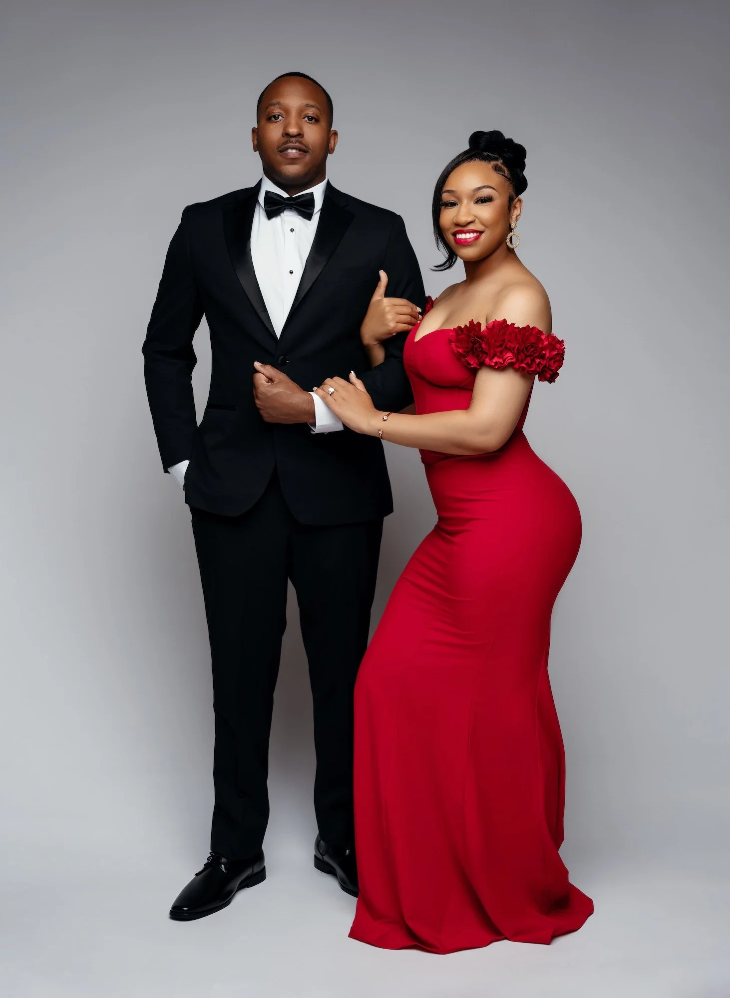 Fine-art couple portrait: formal couple with the woman in a red dress in the studio