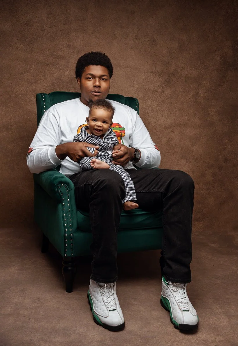 Family photoshoot with father holding baby on green chair in Chicago - Filaneyka photo studio