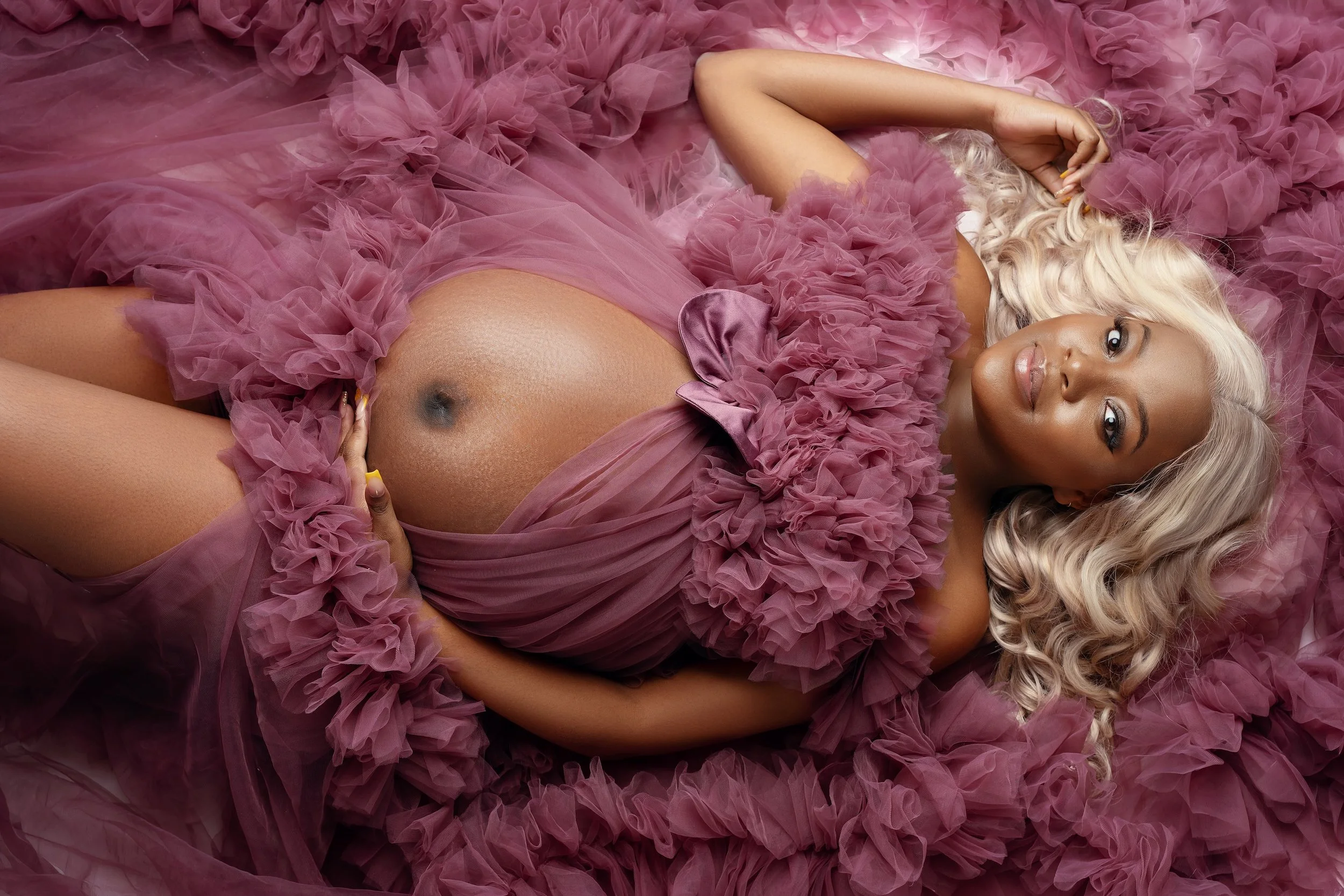 Classic maternity session: pregnant woman in a pink tulle gown in the studio