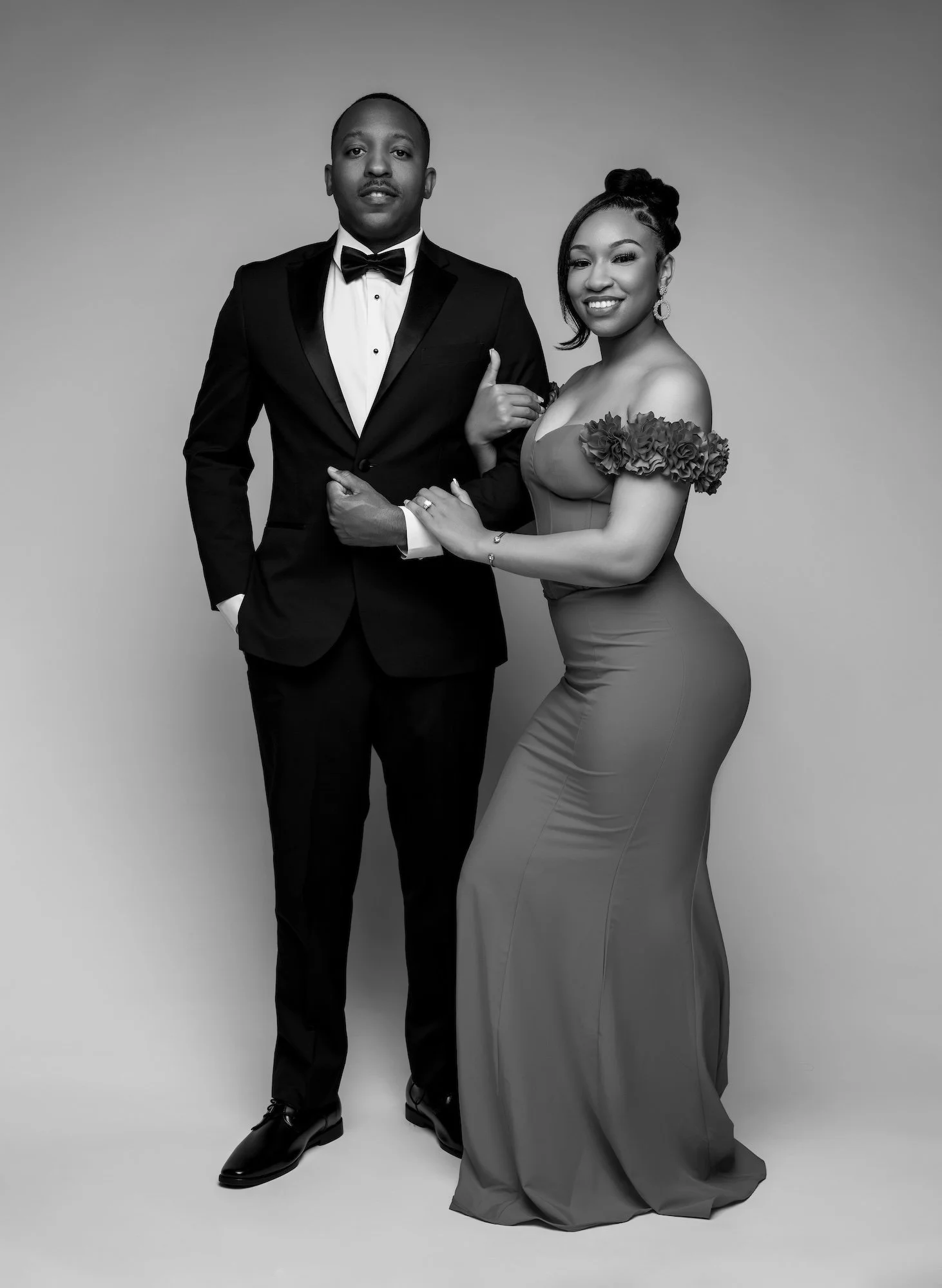 Black and white elegant engagement portrait, couple arm in arm in formal attire, studio photography at Filaneyka Photo Studio