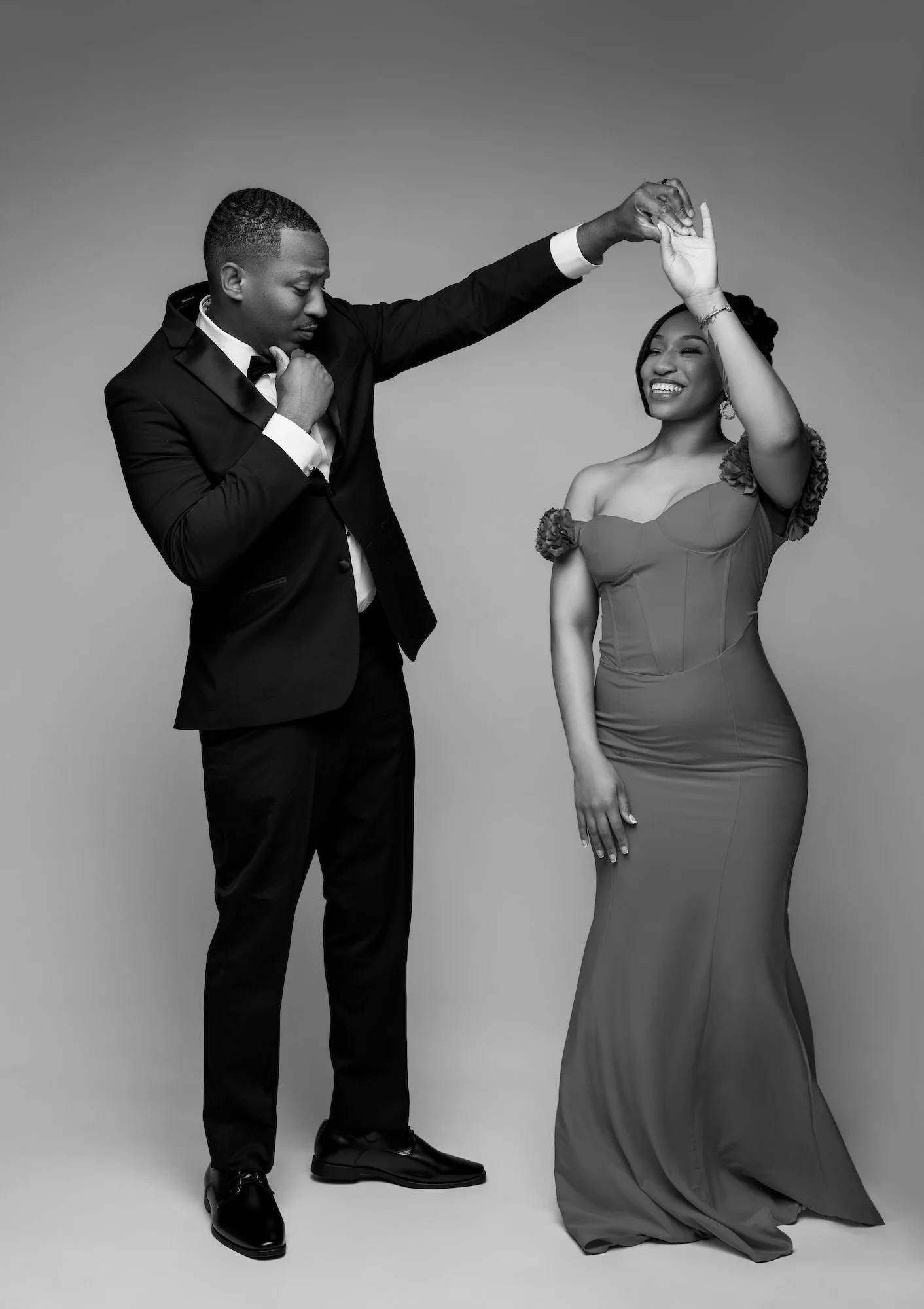 Black and white dancing engagement couple, man spinning woman in red dress, romantic studio photography at Filaneyka