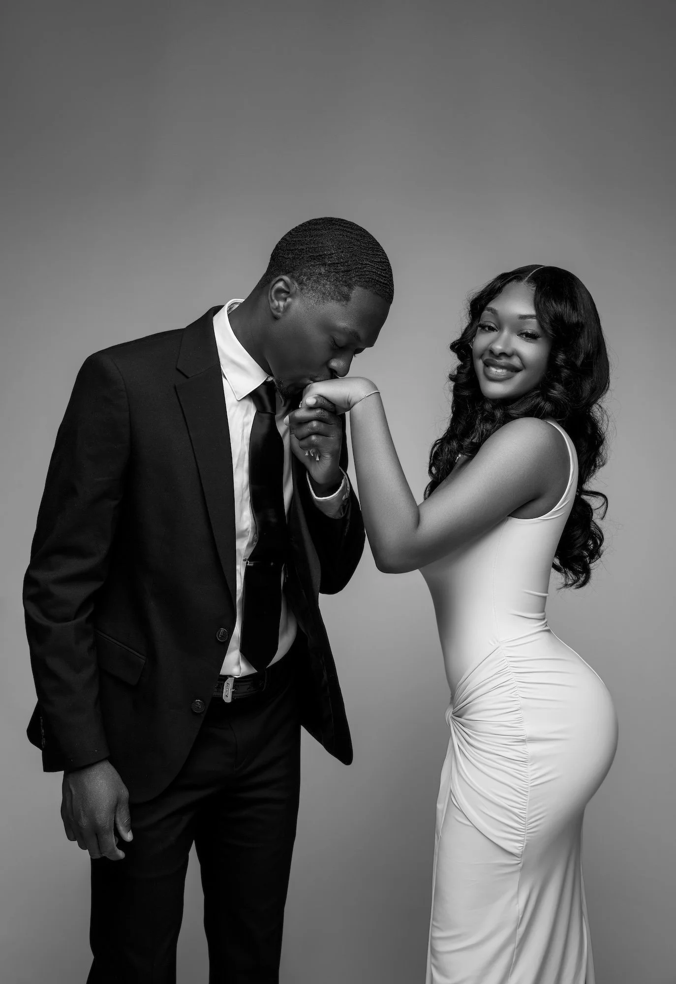 Black and white romantic engagement portrait, man kissing woman's hand, elegant studio photography at Filaneyka Photo Studio Chicago