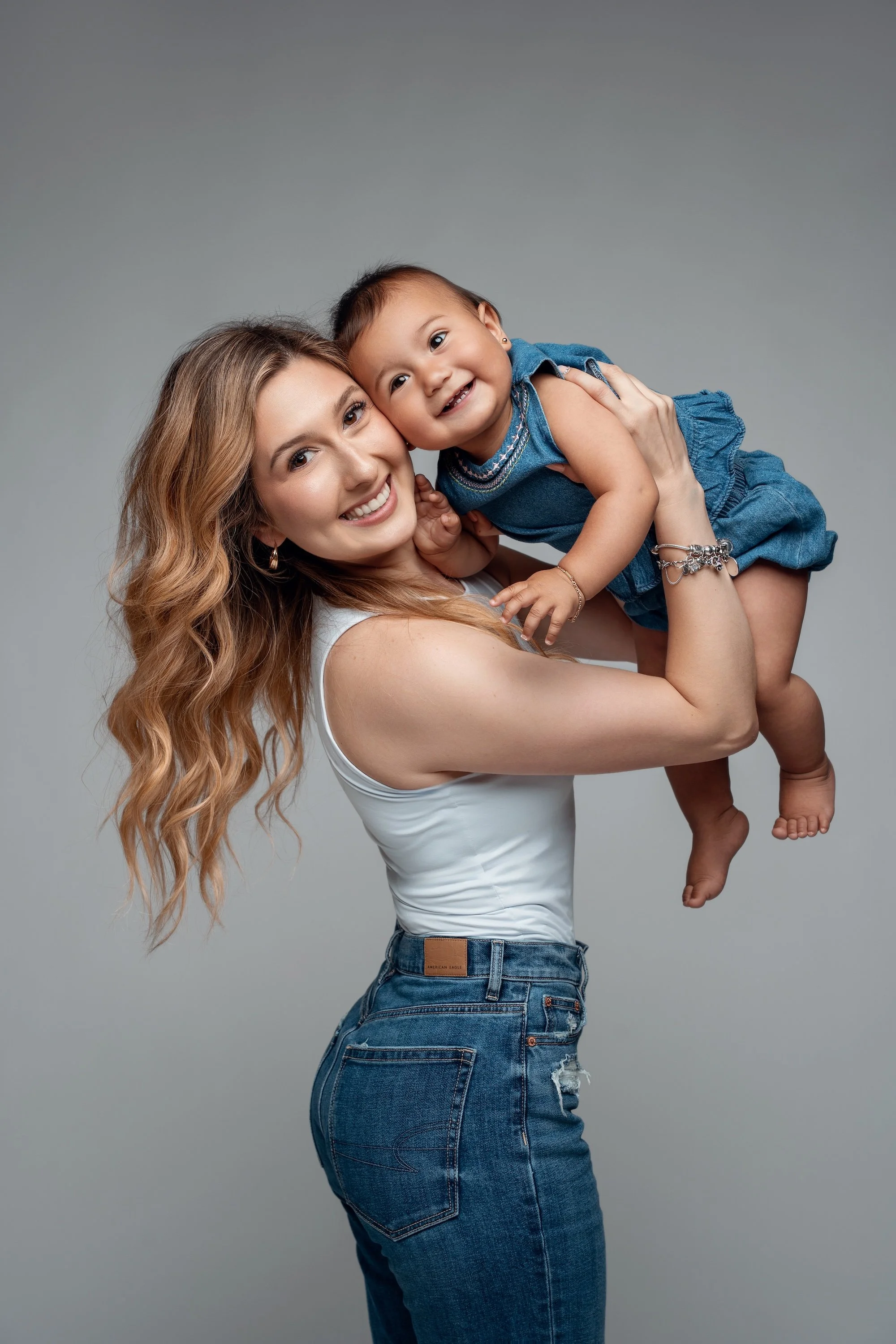 Family portrait session with mom lifting baby in denim outfit in Chicago - Filaneyka photo studio