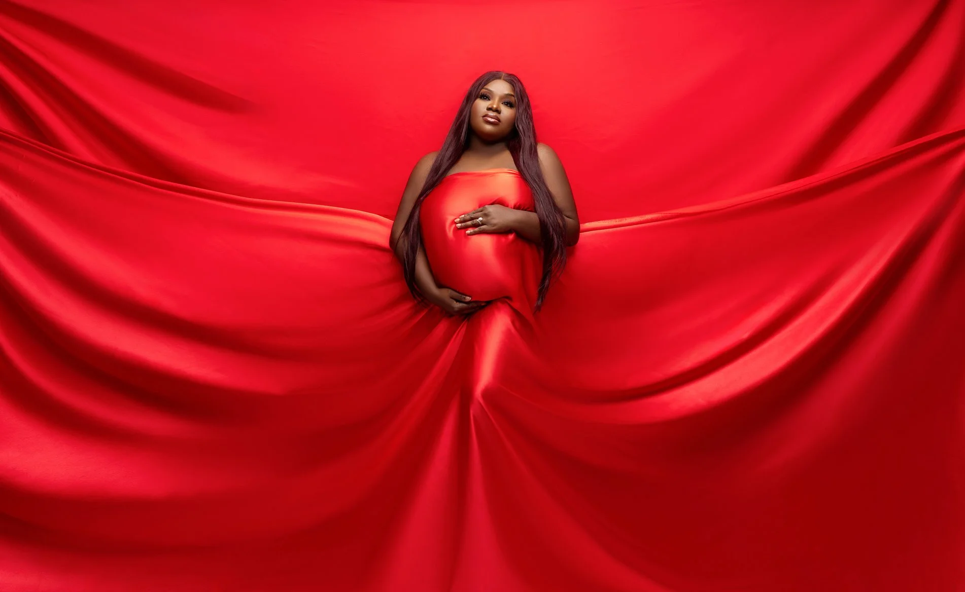 Maternity photoshoot with red fabric draped maternity portrait in Chicago - Filaneyka photo studio