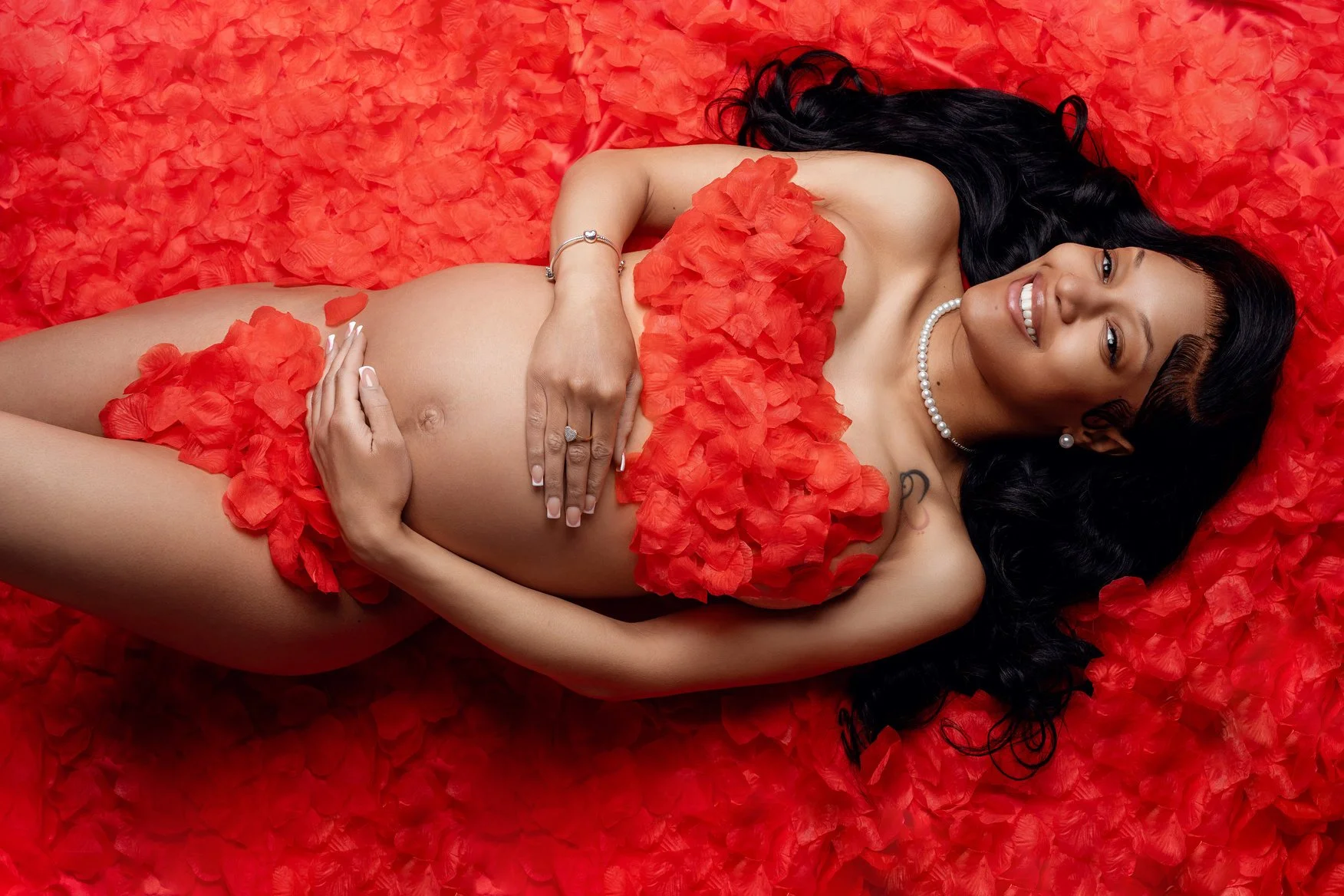 Pregnancy photography with lying on red petals pregnant in Chicago - Filaneyka photo studio