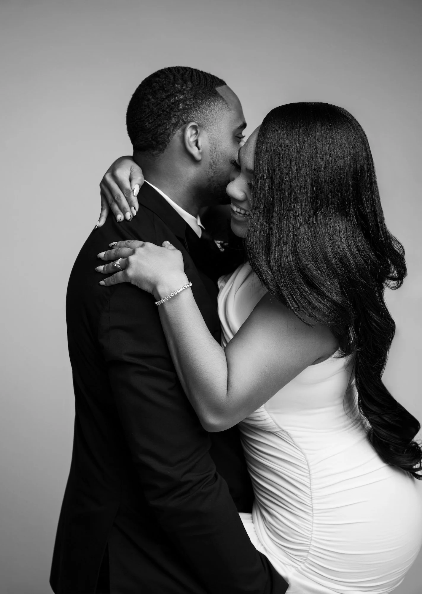 Black and white intimate engagement embrace, couple in formal attire, romantic studio photography at Filaneyka Photo Studio