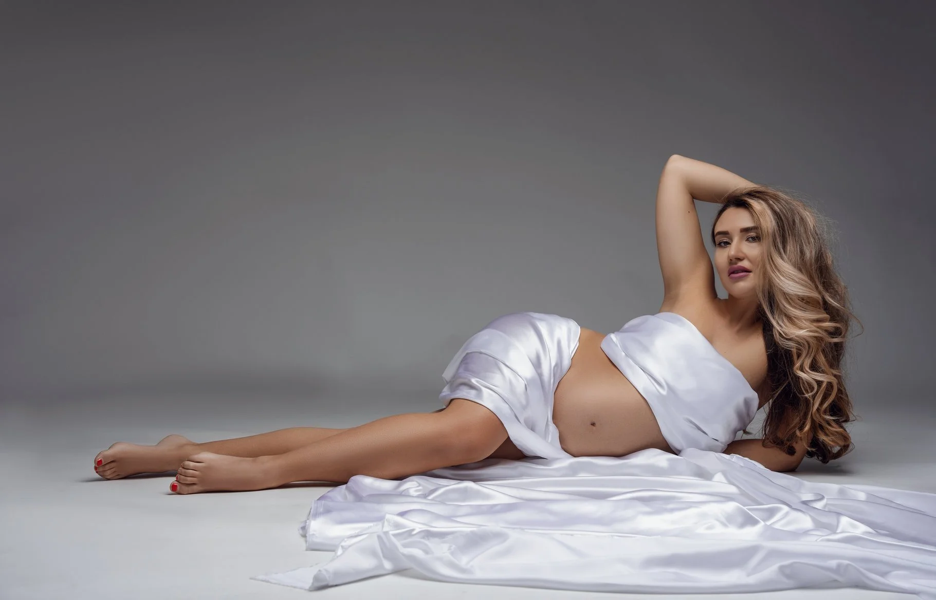 Prenatal photography session with blonde reclining in white silk in Chicago - Filaneyka photo studio