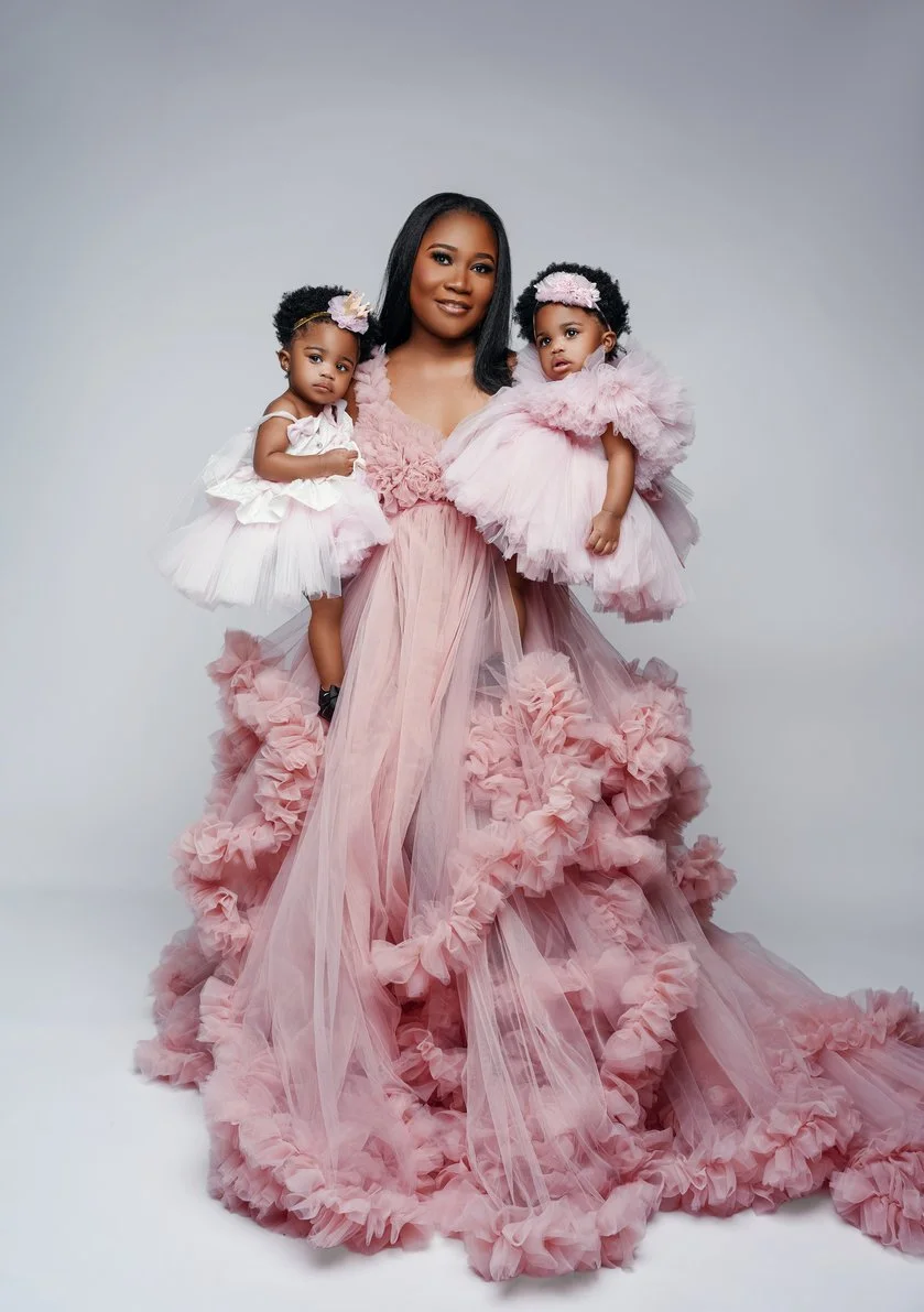 First birthday portrait with mother holding two daughters in pink ruffled gown in Chicago - Filaneyka photo studio