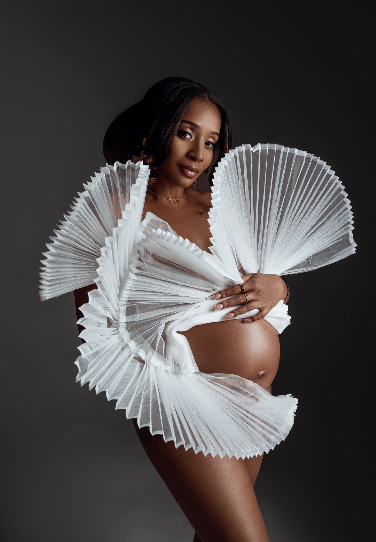 Expecting mother photoshoot with white pleated fan maternity fashion in Chicago - Filaneyka photo studio