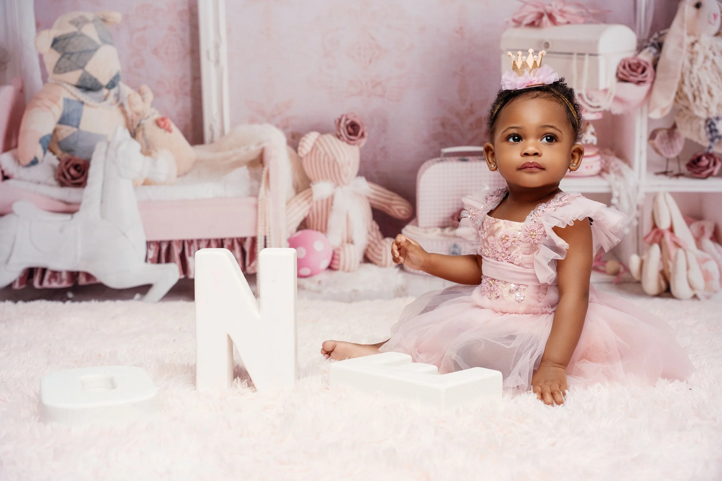 Boutique first birthday portrait: baby girl in a pink dress