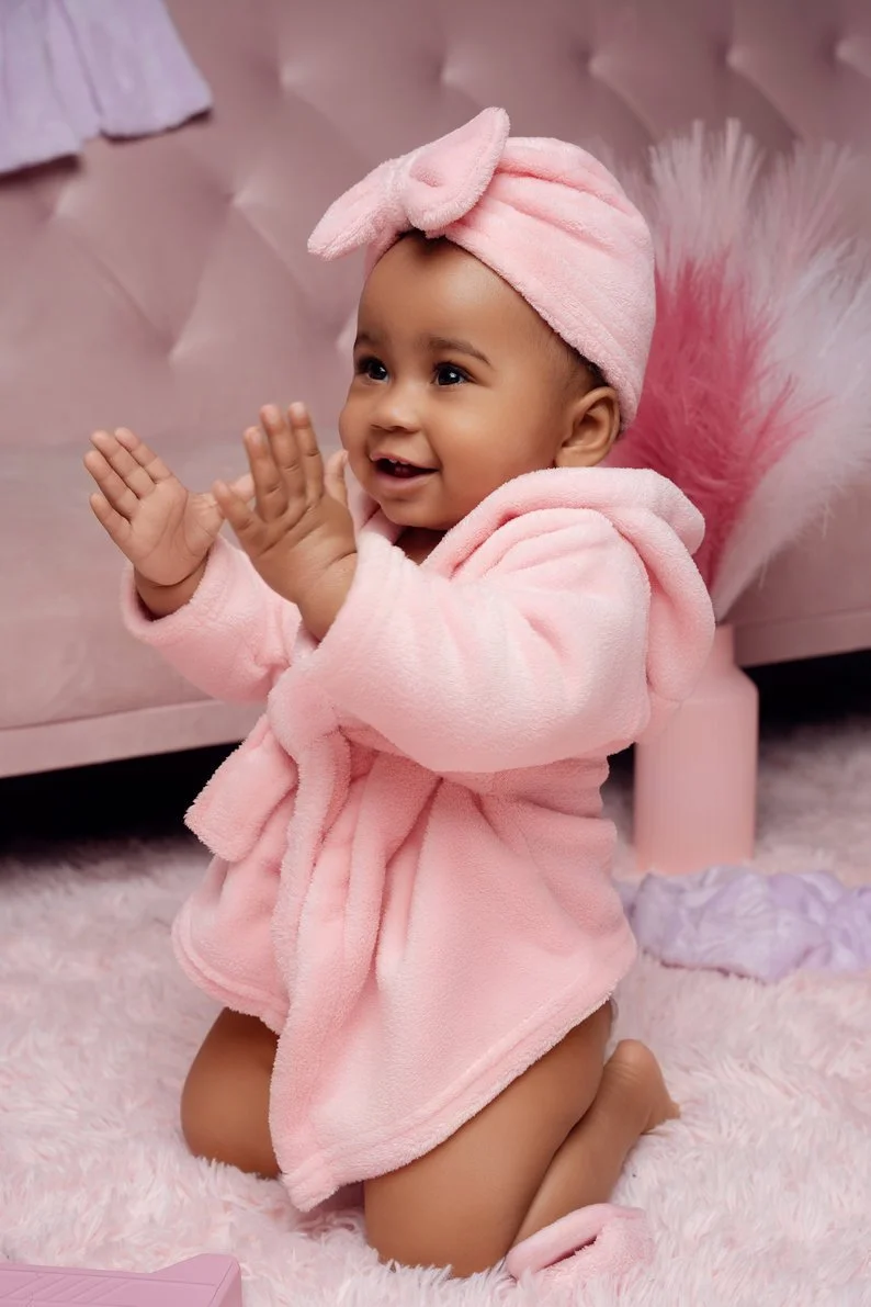 1st birthday photography with baby girl clapping in pink robe headband in Chicago - Filaneyka photo studio