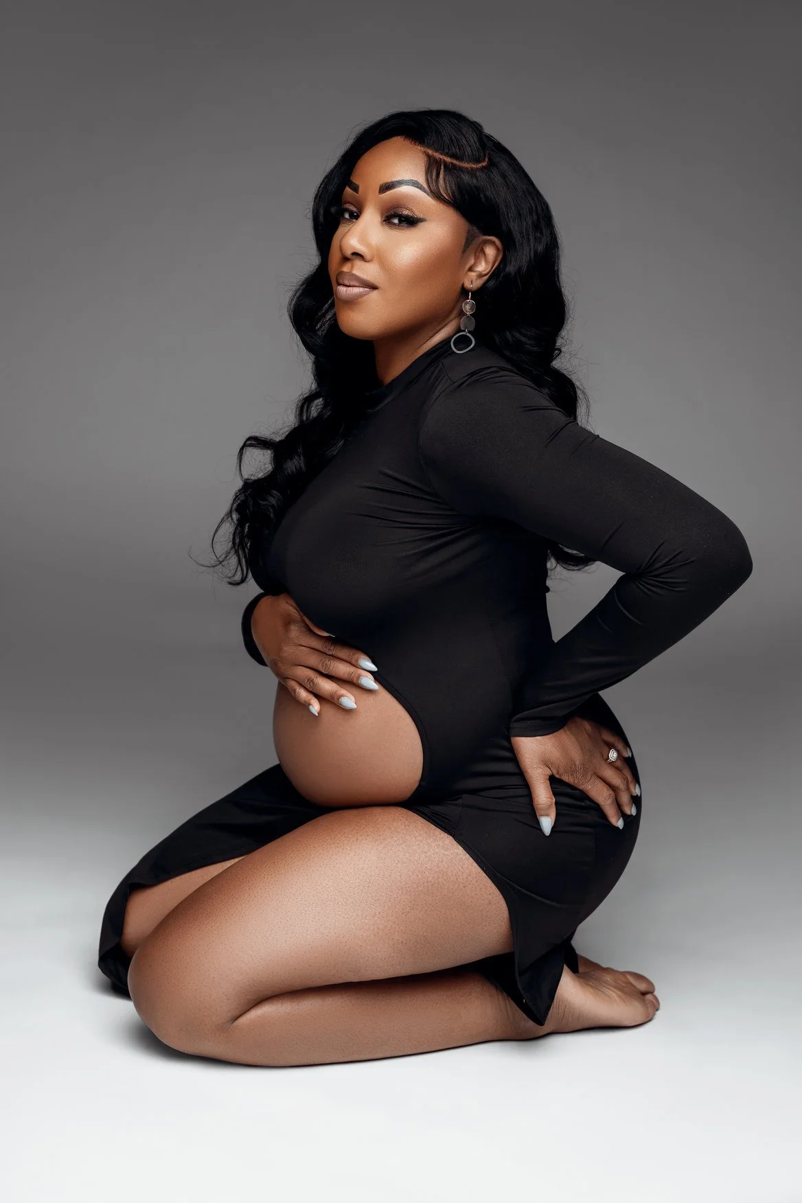 Pregnancy photography with kneeling in black maternity bodysuit in Chicago - Filaneyka photo studio