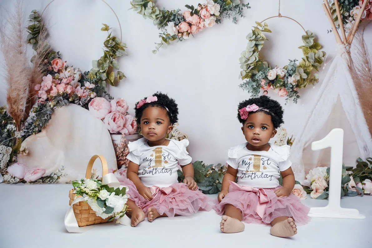 Baby milestone photoshoot with twin girls sitting in matching pink outfits in Chicago - Filaneyka photo studio