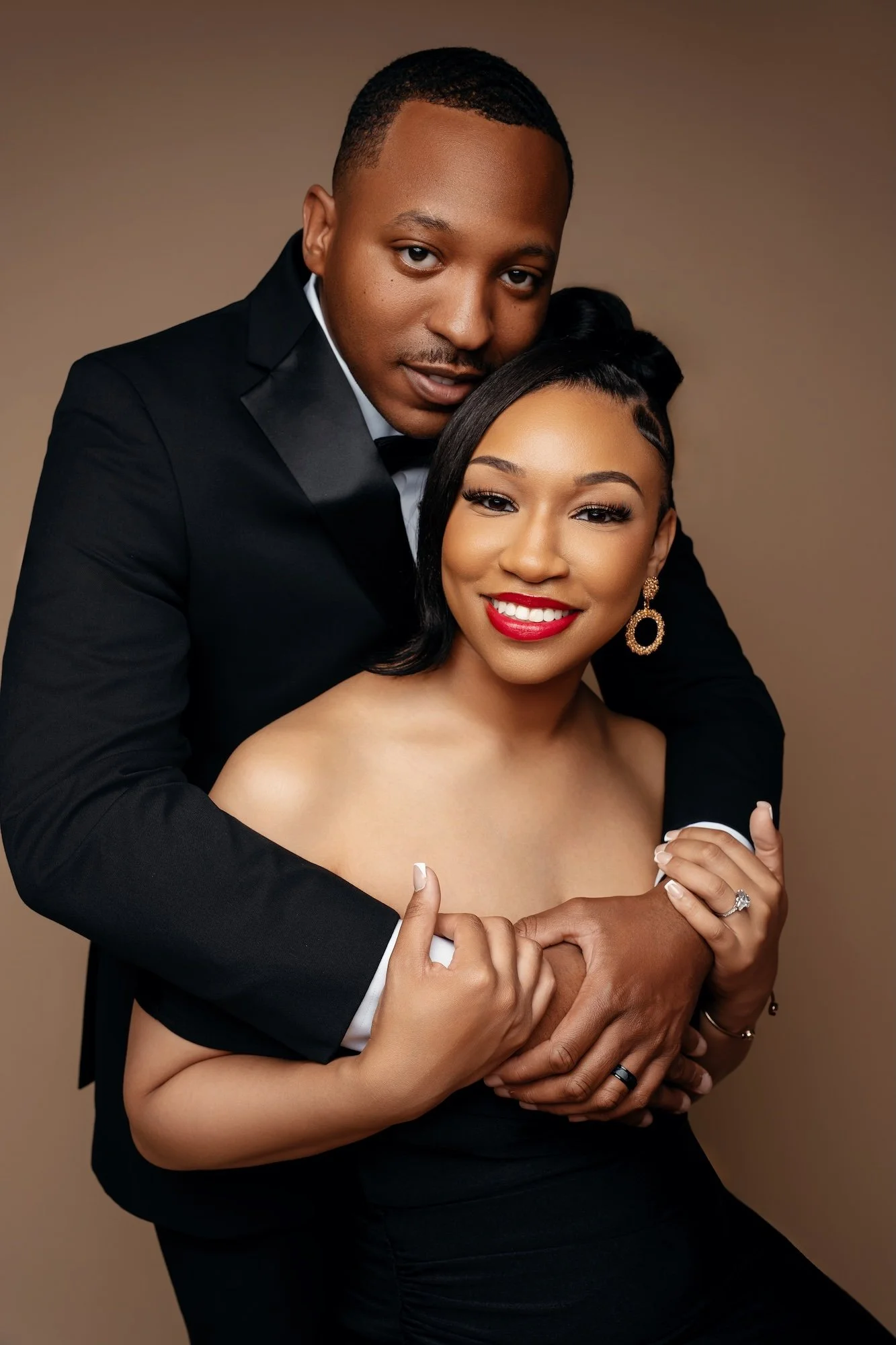 Boutique engagement portrait: couple in formal attire with the woman in a red dress