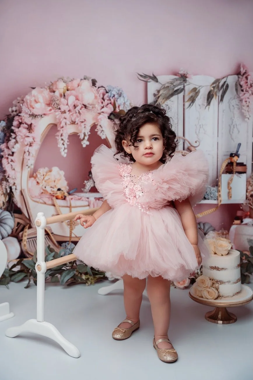 Family photoshoot with girl standing in pink dress beside cake in Chicago - Filaneyka photo studio