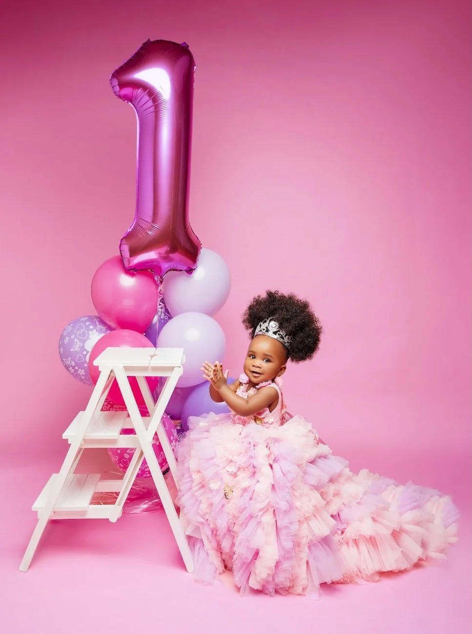 Baby milestone photoshoot with baby girl with number one balloon on pink backdrop in Chicago - Filaneyka photo studio