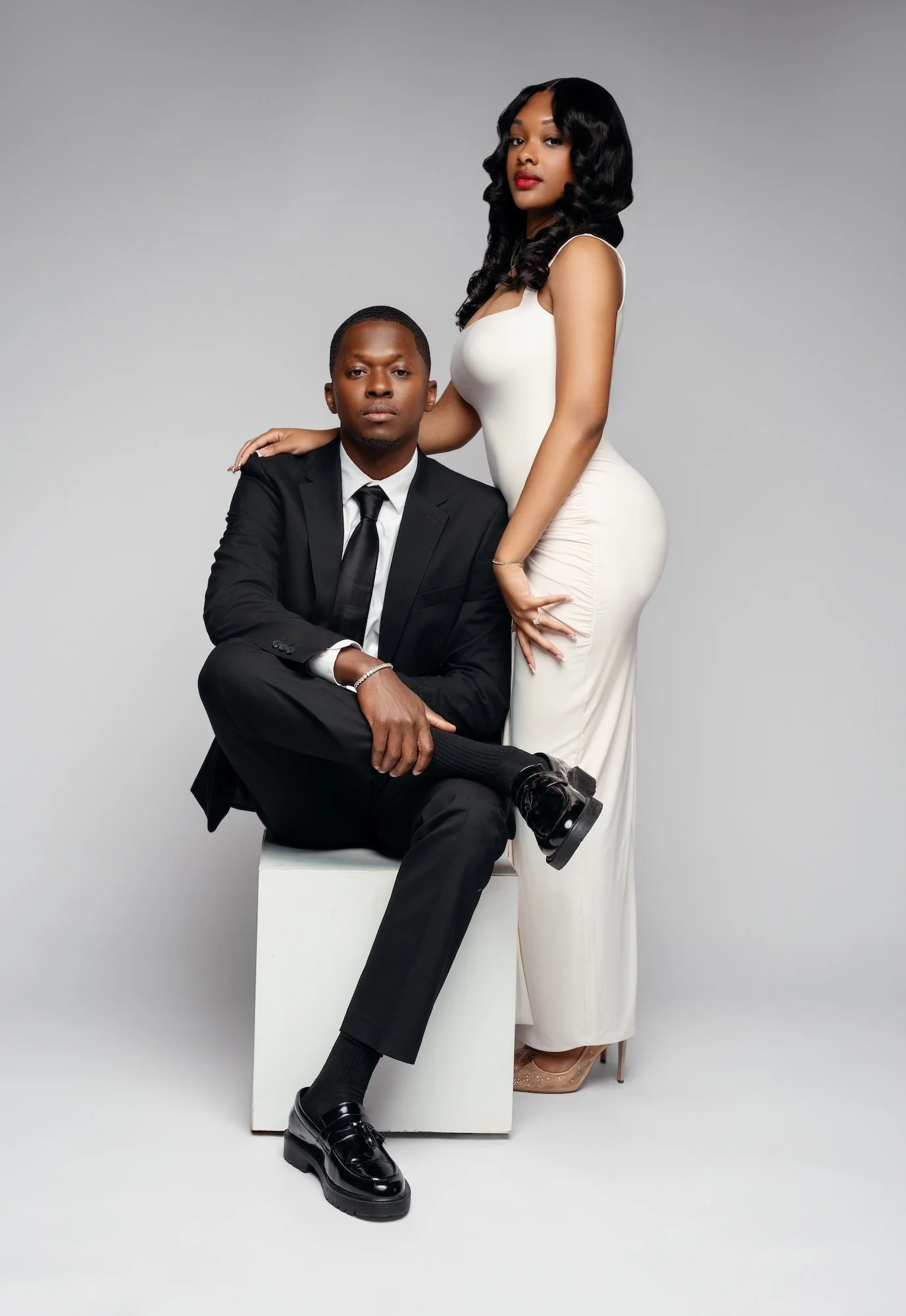 Luxury engagement portrait: couple in formal attire with the woman in a white gown
