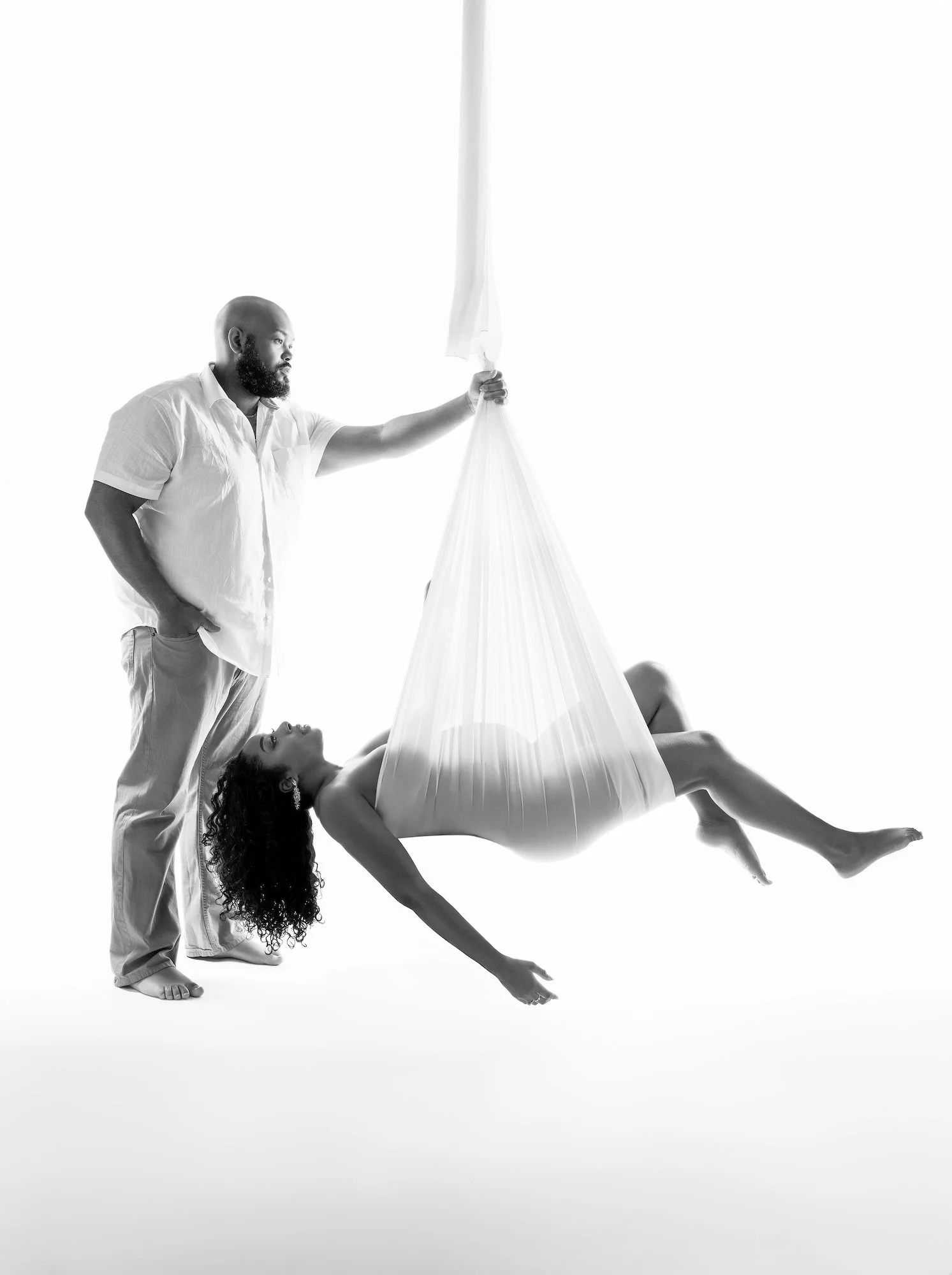 Classic maternity session: pregnant woman draped in fabric wrap with her partner