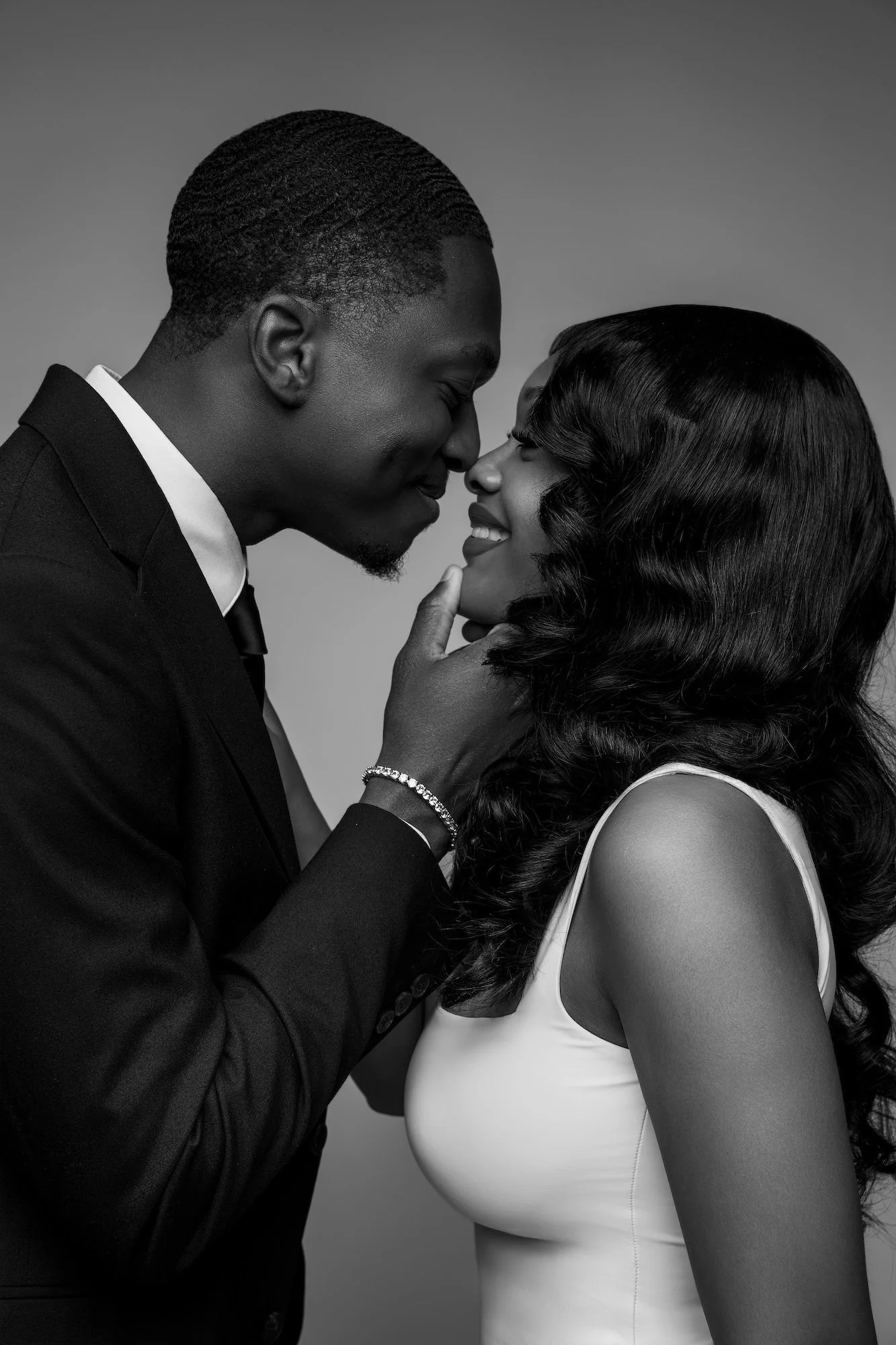 Black and white engagement couple closeup, man in suit touching woman's chin, elegant studio portrait at Filaneyka Chicago