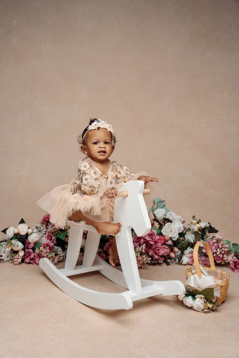 Cake smash session with baby girl on rocking horse with floral backdrop in Chicago - Filaneyka photo studio