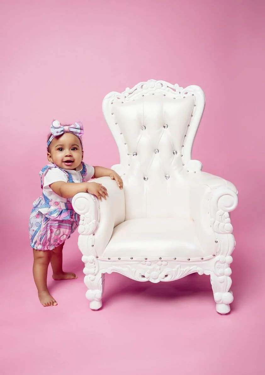 First birthday photoshoot with toddler standing beside white throne in Chicago - Filaneyka photo studio