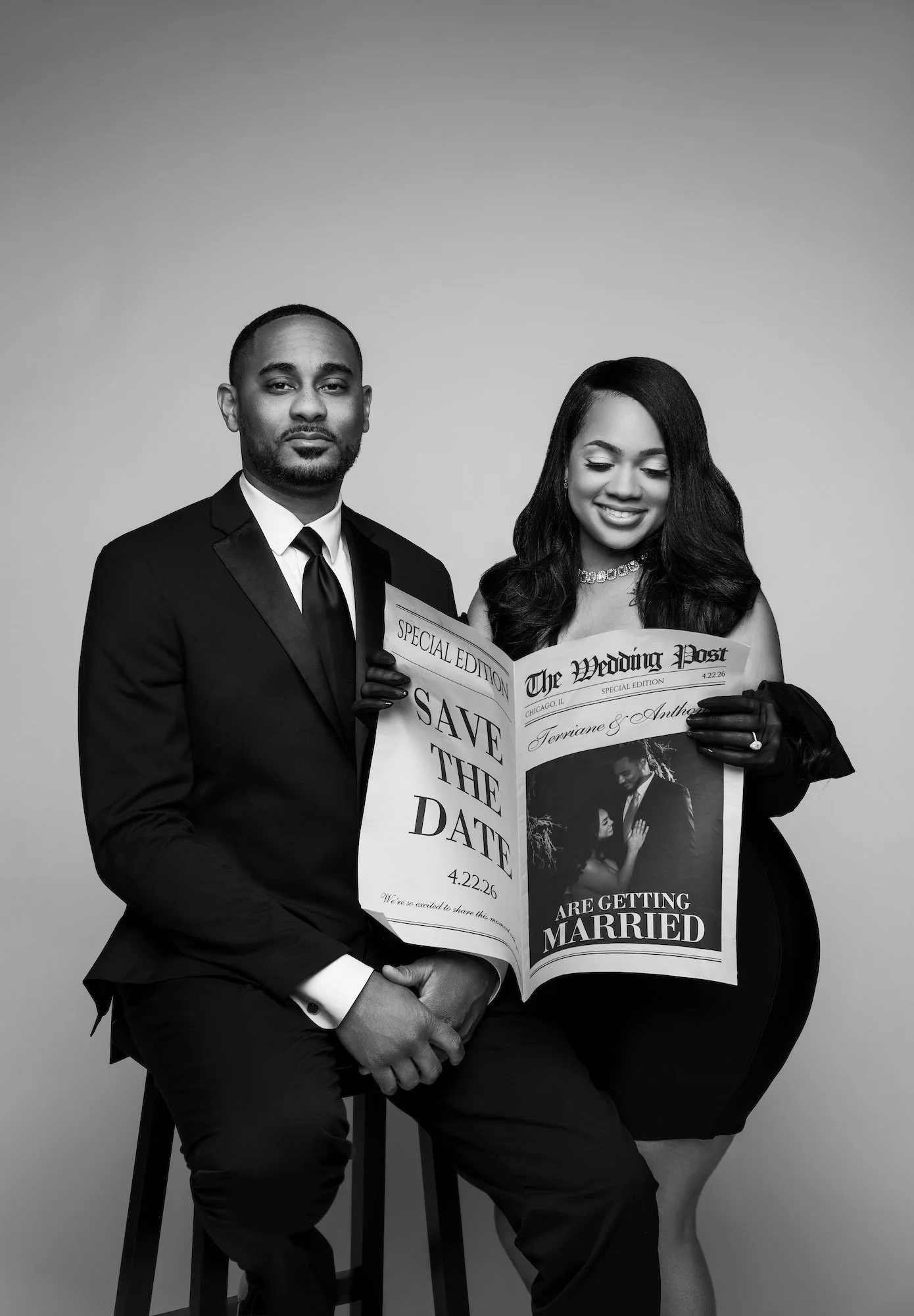 Black and white save the date engagement photo, couple with wedding newspaper prop, studio photography at Filaneyka Photo Studio Chicago