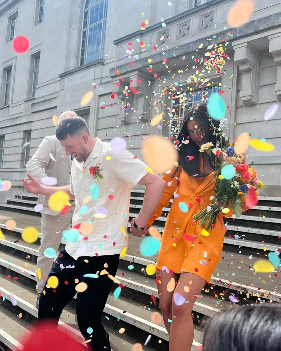multicoloured confetti, flowers, two people getting married
