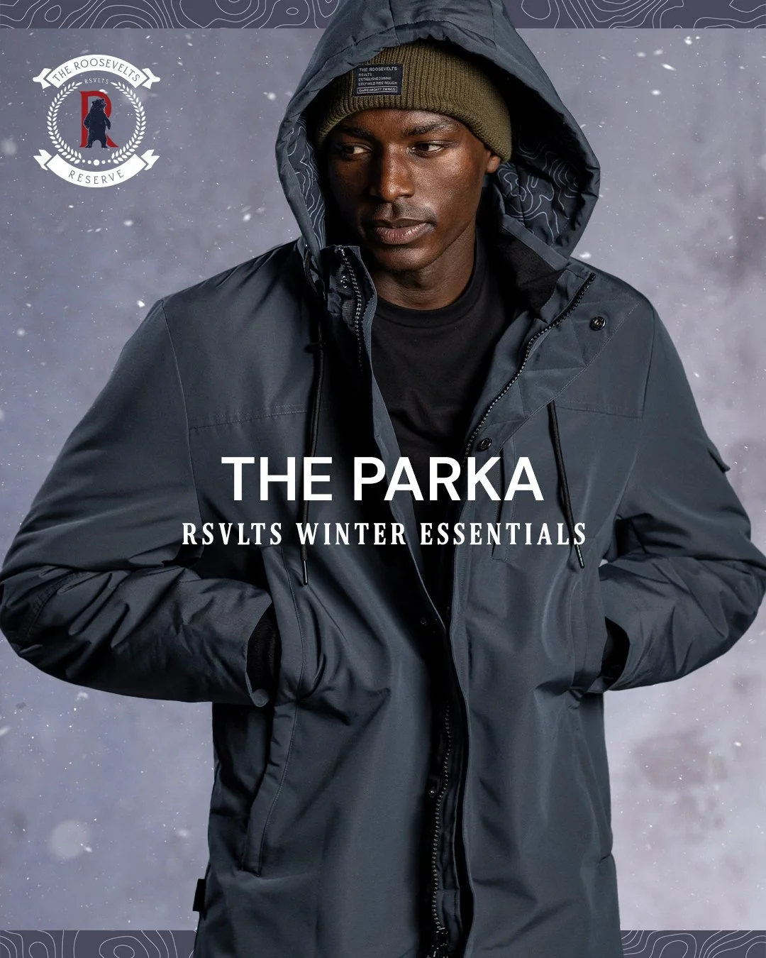 A man wearing a dark rain jacket with the hood up, a brown beanie, and a black shirt, standing against a snowy background. The image promotes The Roosevelt RSVLTS Winter Essentials collection.