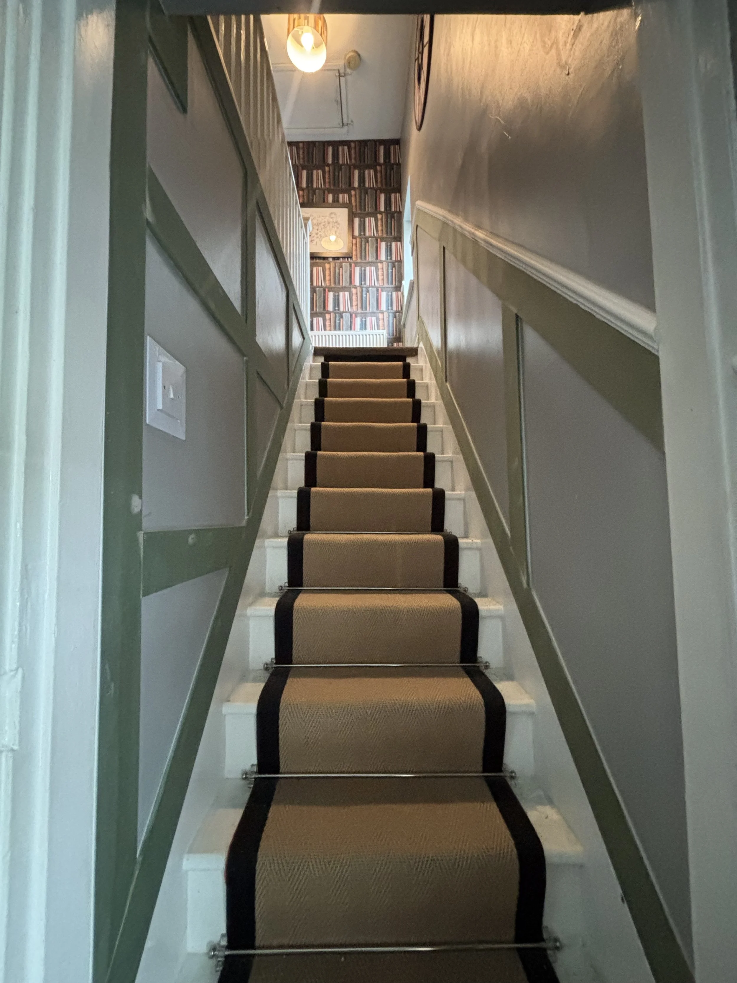 Half height shaker in living room leading to staircase feature wall
