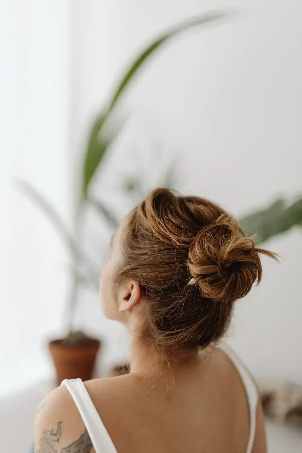 Women with bun in white tank decompressing after trauma therapy