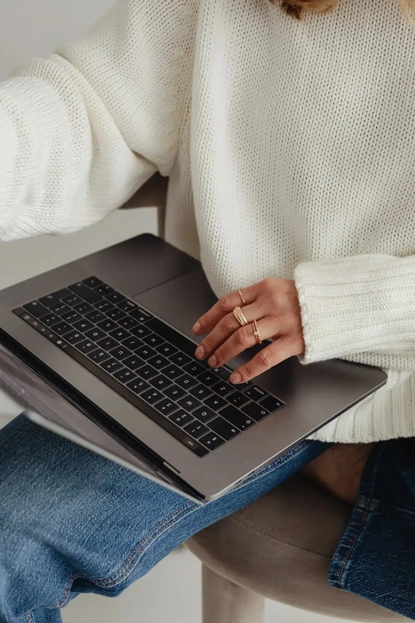 Women in white sweater on her laptop booking therapy for anxiety consultation
