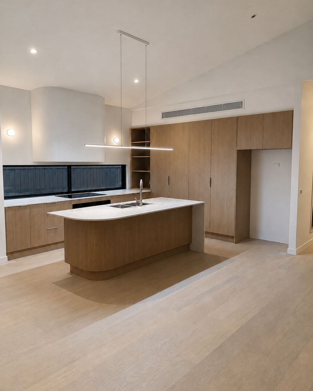 Kitchen with timber joinery, curved island and raked ceiling — Chambers Road, Altona North.