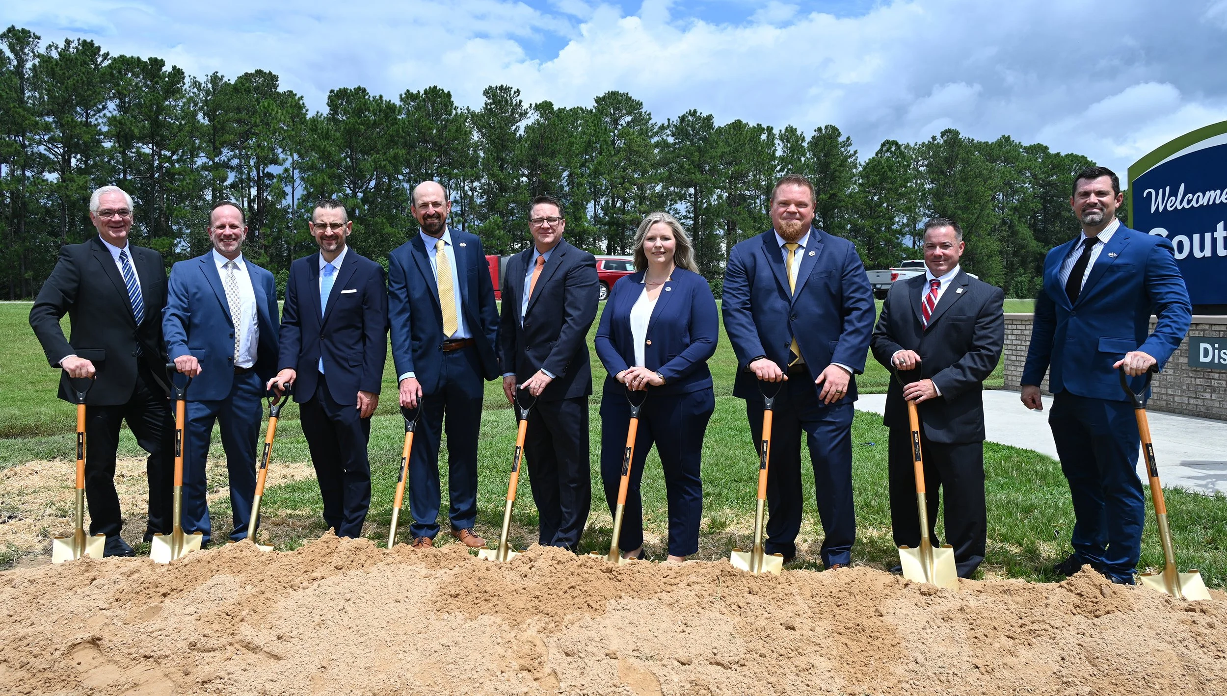 Group of officials with gold shovels stand together on site for the I-95 Widening and Improvements groundbreaking.
